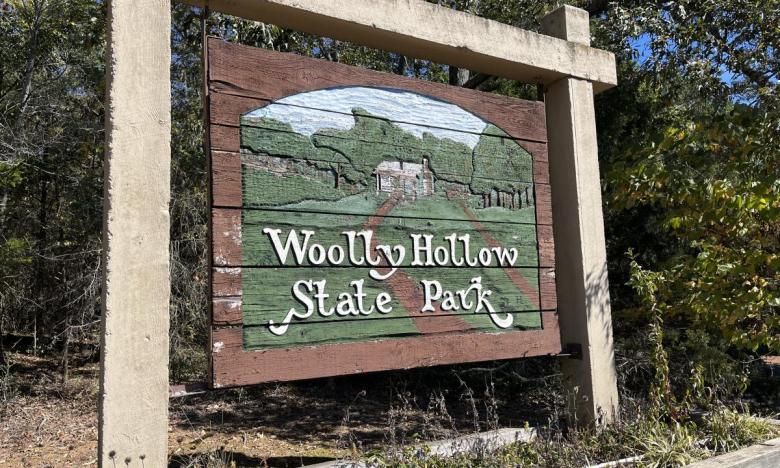 View of entrance sign for Woolly Hollow State Park. 